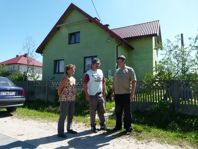 Sołtys Topolic Henryk Twardowski (od prawej) w rozmowie z Urszulą i Piotrem Murawskimi, których dom, na tle którego stoją, budowany był od podstaw