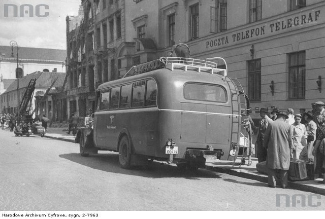 Autobus dalekobieżny na przystanku przed urzędem pocztowym. Widoczni pasażerowie z bagażami. Lata 1939 - 1945.