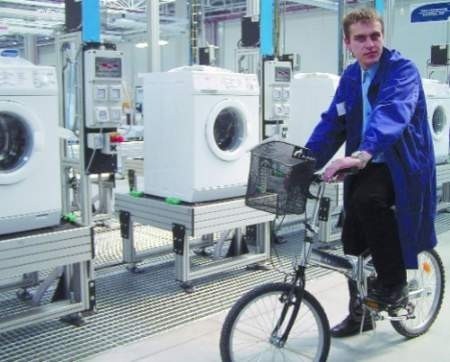 Fabryka w Oławie jest tak duża, że Mariusz Gużda jeździ po niej na rowerze. To jego pierwsza praca po studiach.
Fot. Michał Gigołła