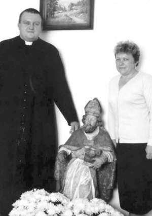 Ksiądz Tomasz Kryczko i Zofia Nabrdalik przy figurze świętego.