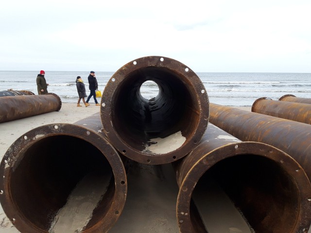 elementy rurociągu czekają na plaży na montaż