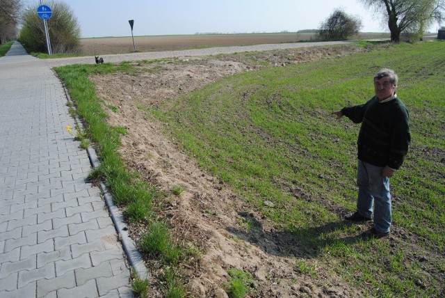 Jan Mączkowski z Ruchocic pokazuje jak wiele ziemi wybrano z jego pola przy budowie ścieżki pieszo-rowerowej