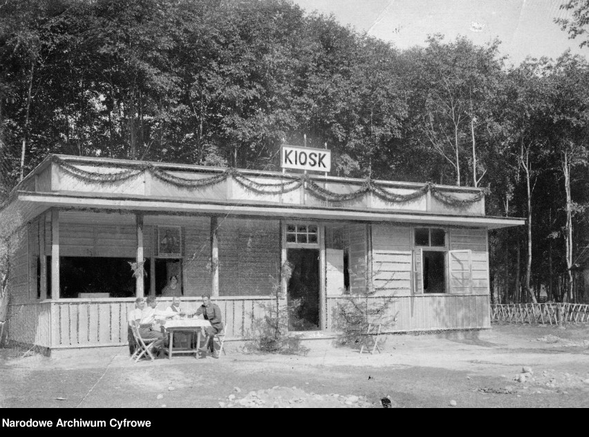 Kiosk (sklep) w Przemyślu. Przed kioskiem przy stole siedzą...