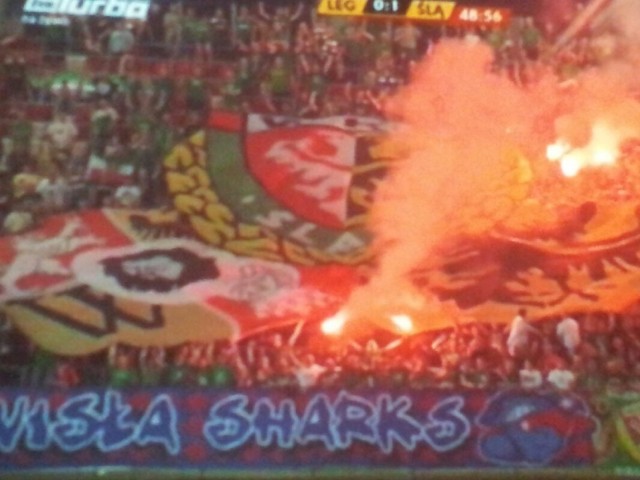 Kibice Śląska rzucają kolorowe ogniste race na płytę stadionu