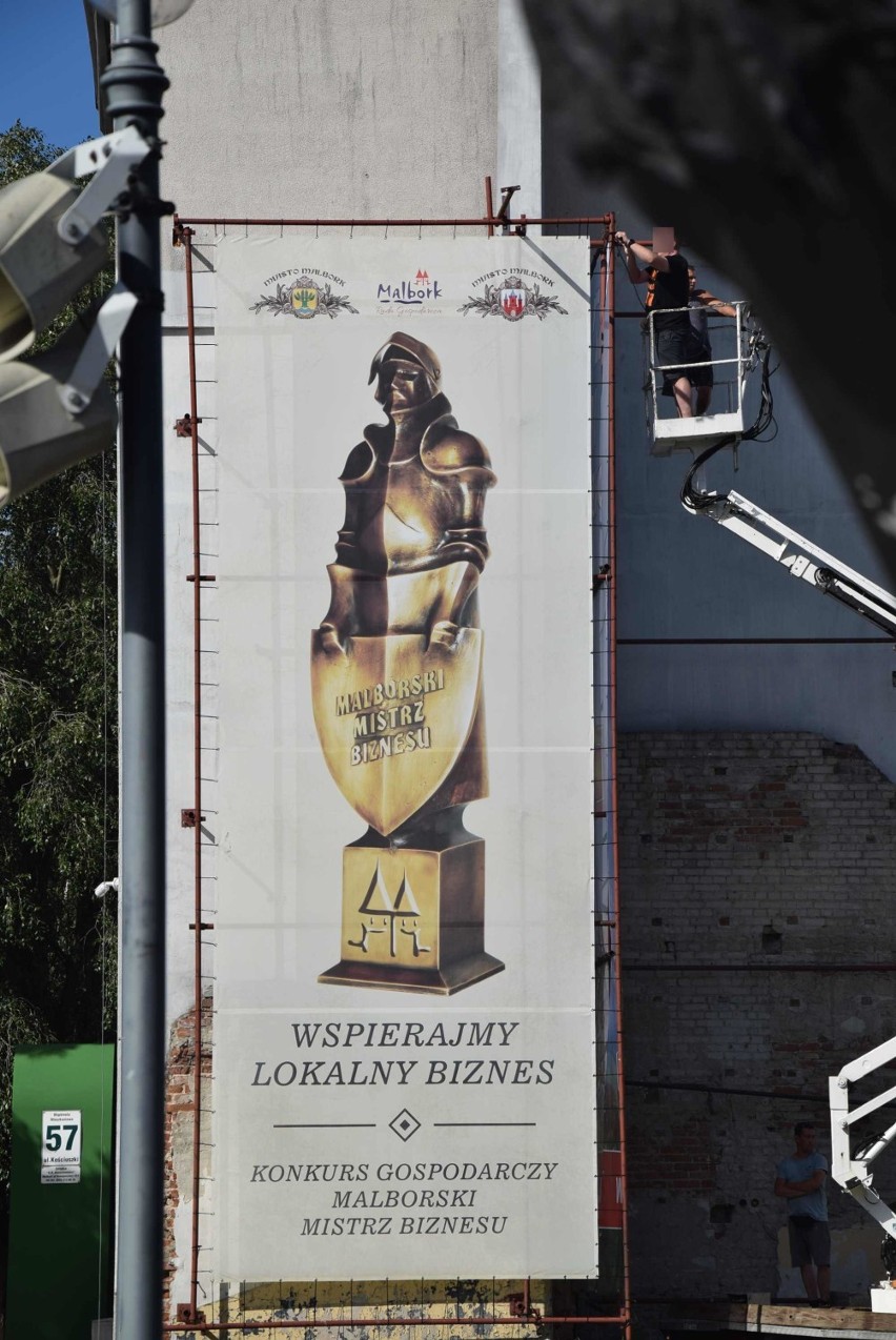 Malbork. Brzydka ściana w centrum miasta została przesłonięta miejskimi reklamami. Już można oglądać efekty