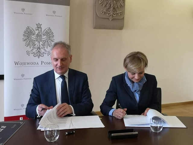 Wojewoda pomorski Dariusz Drelich i burmistrz Jolanta Szewczun podpisują umowę