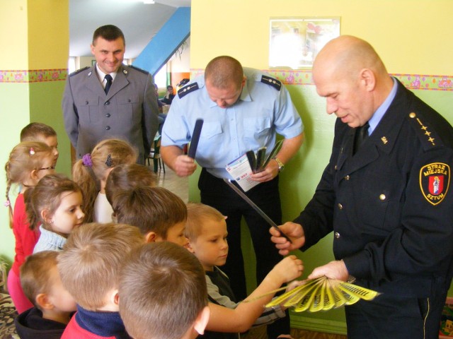 policjanci i strażnicy miejscy spotykają się z dziećmi i objaśniają zasady bezpieczeństwa.