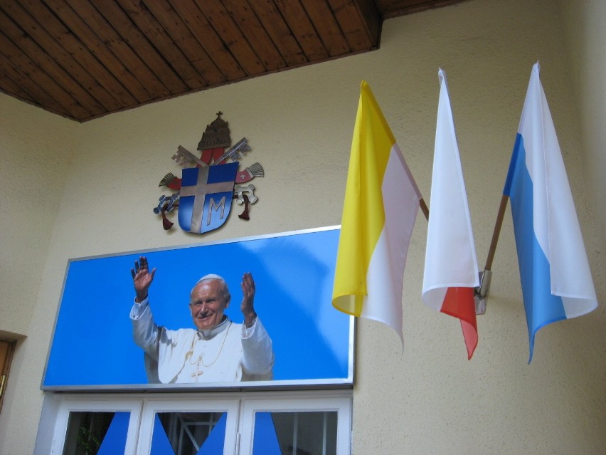 Nad oknem domu Ojca Świętego widoczne są trzy flagi -...