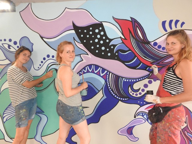 Joanna Róg-Ociepka,  Anna Czermak i Karolina Oczkowska podczas prac przy malowaniu pierwszego w Wadowicach murala na ścianie przejścia podziemnego przy dworcu kolejowym