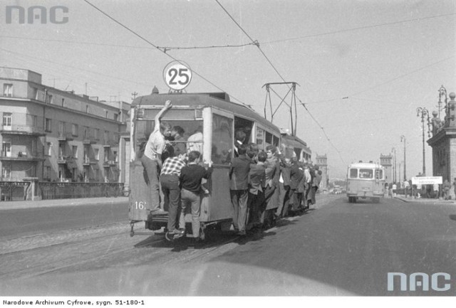 Zatłoczony tramwaj nr 25. Widoczny wagon typu 4ND z pasażerami uwieszonymi na tak zwane "winogrono".