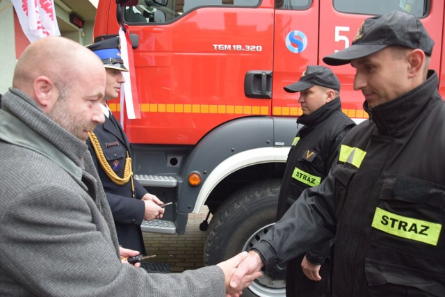 Wicestarosta Robert Fabisiak przekazuje strażakom kluczki do nowych pojazdów