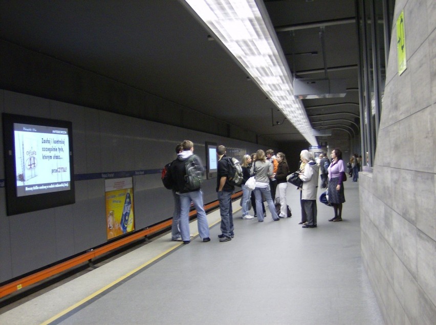 Telebimy przyciągają uwagę oczekujących na wagony metra.