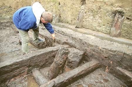 Archeolog Mirosław Marcinkowski odsłania fragmenty drewnianych domów z XIII wieku