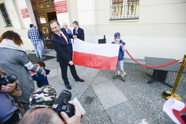 Burmistrz Michał Kołaciński dzień wcześniej rozdawał flagi mieszkańcom Oleśnicy i prosił, by wywieszać je podczas świąt państwowych. Jego podwładni zapomnieli jednak dzień później o fladze na maszcie pod pomnikiem