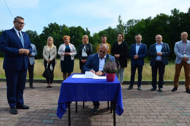 Umowę na budowę przedszkola podpisali burmistrz Myślenic Jarosław Szlachetka (z lewej) i Jan Cabak, właściciel firmy Eko-Rem-Bud (siedzi przy stole). W tle działka, a której stanie budynek