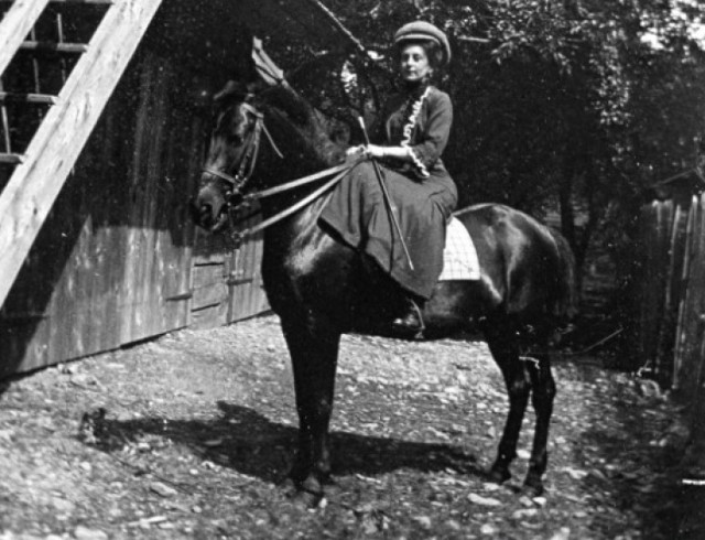 Właścicielka apteki, amatorka fotografii Klementyna Zubrzycka-Bączkowska na koniu z tyłu swego domu w Limanowej , ok. 1905 r.