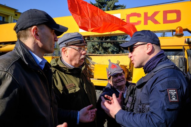 Marcin Maruszak (pierwszy z lewej) i Adam Słomka rozmawiają z funkcjonariuszem policji w sprawie wpuszczenia na pl.  Ofiar Getta dźwigu do rozbiórki Pomnika Wdzięczności Armii Czerwonej.