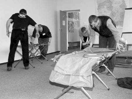 Przemysław Dabkowski, Dariusz Margiel, Paweł Rudecki i Artur Rybacki przygotowują pomieszczenie dla poszkodowanych.