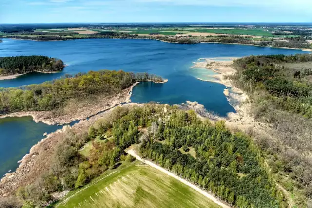 Jezioro Lubikowskie to najczystszy i najładniejszy akwen lubusko-wielkopolskiego pogranicza. To miejsce zachwyca nie tylko piękną wodą, ale też bujną naturą wokół oraz dobrą infrastrukturą, która zachęca do wypoczywania właśnie tutaj.

Byliście kiedyś w Lubikowie? Jeśli nie, to powinniście to zmienić. Wystarczy przyjechać na parking (za zaparkowanie auta płaci się 10 zł) przy jeziorze, by zobaczyć, że to miejsce doceniają nie tylko mieszkańcy powiatu międzyrzeckiego, ale też osoby z innych stron naszego regionu oraz mieszkańcy Wielkopolski. Dlaczego to miejsce cieszy się taką popularnością? Jak już wspomnieliśmy. Woda jest czysta (miłośnicy nurkowania mogą to potwierdzić), a plaża ma nie tylko piękny pomost, ale też sporo atrakcji dla najmłodszych wczasowiczów. W pobliżu są stosika gastronomiczne, kilka ławek i sklepik.

Grzegorz Walkowski pokazuje na swoich podniebnych fotografiach, jak to jezioro wygląda z lotu ptaka. Brak planów na wolny dzień, czy weekend? To może skusicie się na Lubikowo?

Przeczytaj też:
Lubikowska perełka szykuje się do sezonu. Będzie... pływające SPA!

WIDEO: Jezioro Głębokie koło Międzyrzecza: porównanie poziomu wody z 2017 r. do 2020 r. Film wykonał Marek Zientecki
