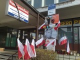 Znicze, kwiaty i flagi przed biurem poselskim Przemysława Gosiewskiego