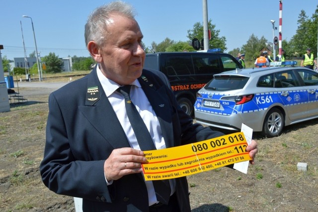 Andrzej Matysiewicz - dyrektor Zakładu Linii Kolejowych w Lublinie prezentuje naklejkę z informacją o miejscu zdarzenia
