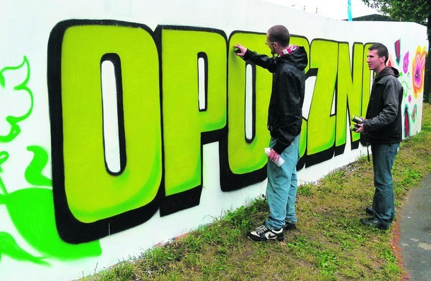 Młodzi grafficiarze na murze oddzielającym plac MDK od parkingu wymalowali napis Opoczno
