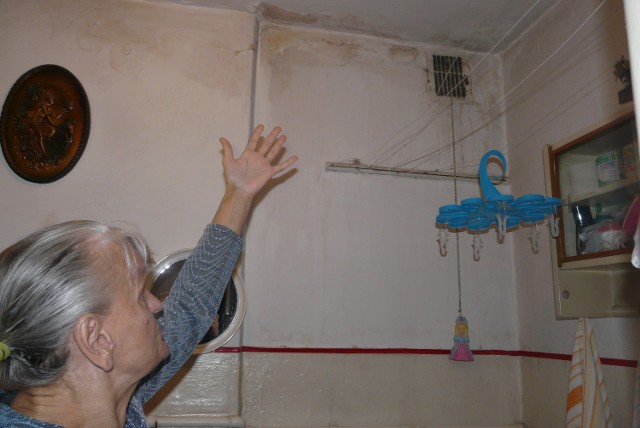 Pani Apolonia pokazuje zalaną ścianę w łazience