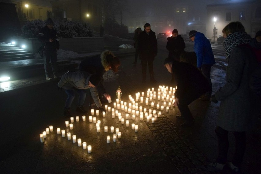 Napis ze zniczy przed katedrą w Kielcach