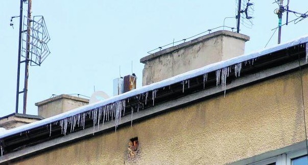 Jeden z budynków na Jeżycach: sople wiszą, a chodnik pod nimi, oznaczony taśmą,  został wyłączony z użytkowania