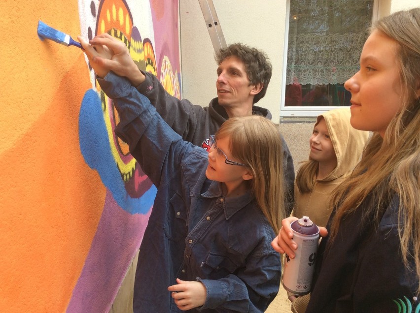 Uczniowie na ścianach szkoły namalowali kolorowy mural.