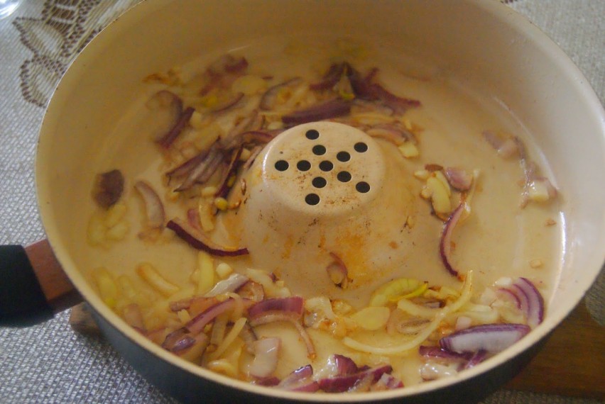 Na rozgrzany olej wrzucić cebulę i smażyć aż się zeszkli.