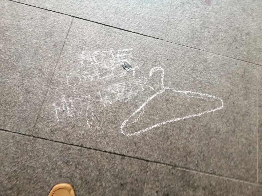 Hasła wymalowane kredą na chodniku w przejściu podziemnym