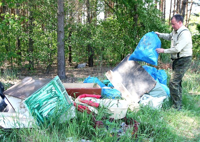 Leśniczy Artur Rupczak pokazuje śmieci, które leżały w podwłocławskich lasach