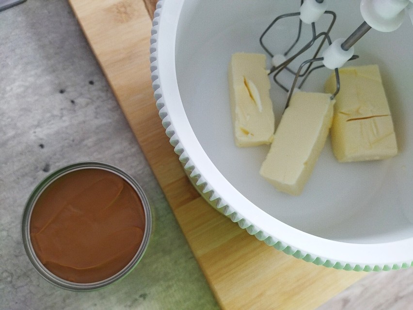 Przygotuj krem kajmakowy: utrzyj miękkie masło, dodawaj...