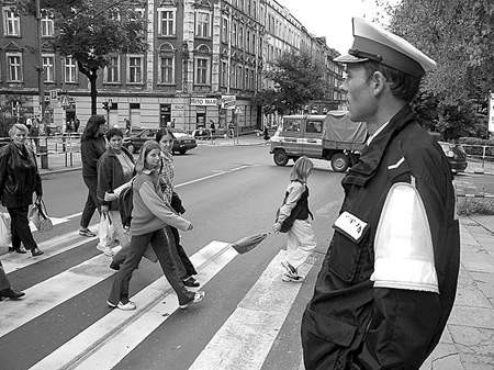 Sierżant Aleksander Karp pilnuje, by dzieci bezpiecznie pokonały ruchliwą ulicę Piłsudskiego w Bytomiu.