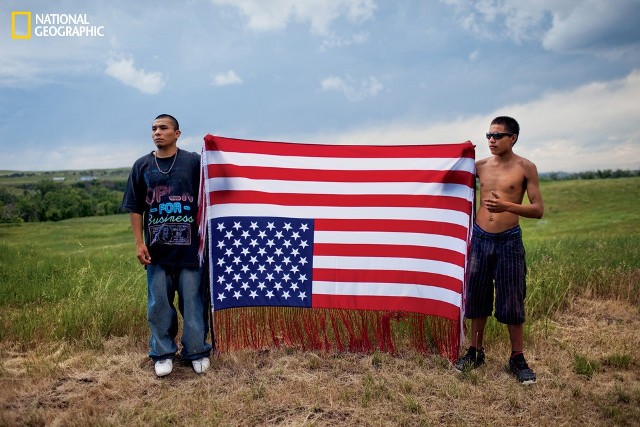 2011 - Południowa Dakota

Młodzi mężczyźni z plemienia Oglala trzymają odwróconą flagę amerykańską do gory nogami – międzynarodowy symbol sprzeciwy wobec rządu USA – na wiecu upamiętniającym starcie między aktywistami z Ruchu Indian Amerykańskich (AIM), a agentami FBI, w którym zginęło dwóch funkcjonariuszy i jeden członek AIM. Działacz ruchu Leonard Peltier został skazany na dożywocie.
