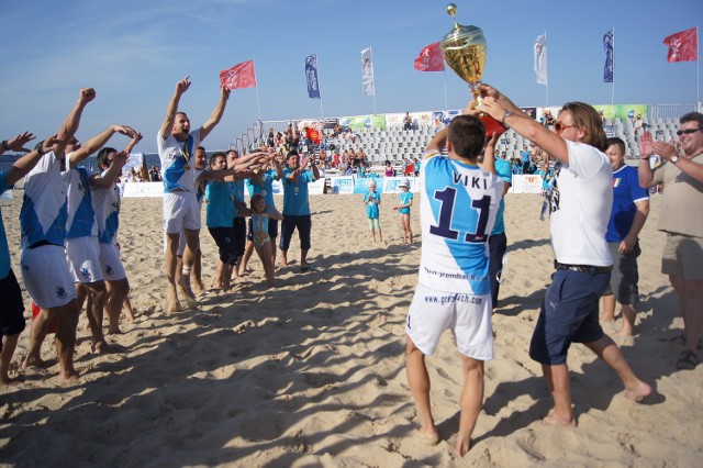 Kapitan drużyny, Witold Ziober, odbiera Puchar z rąk Tomasza Iwana, przewodniczącego komisji PZPN ds. piłki plażowej
