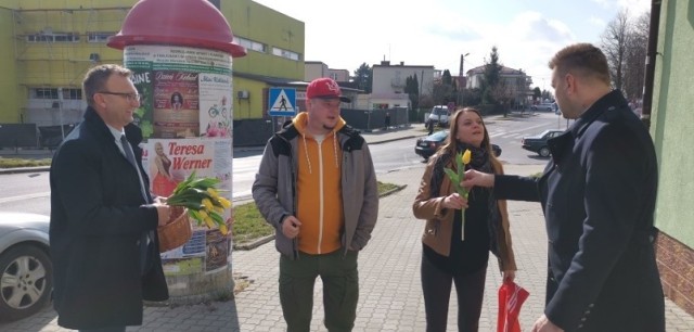 Od lewej starosta Marcin Piwnik z prawej burmistrz Marcin Marzec wręczają kwiaty paniom na sandomierskich ulicach.
