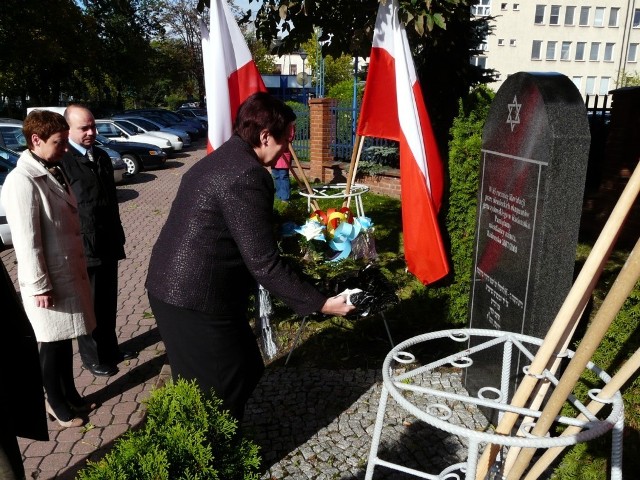 Anna Milczanowska składa kwiaty pod obeliskiem