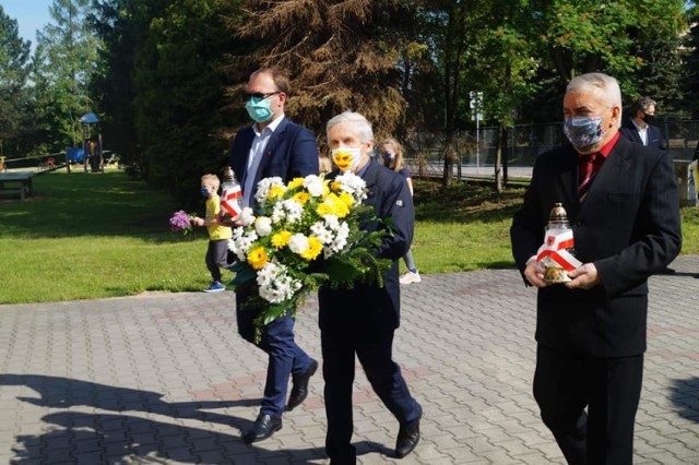 Kwiaty i znicze składają od lewej: wiceburmistrz Łukasz Maderak, burmistrz Adam Bodzioch i przewodniczący Rady Miejskiej, Wacław Piwudzki.