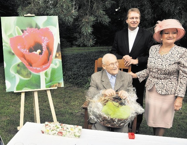 Stefan Stuligrosz z koszem cebulek i rodzicami chrzestnymi przy wizualizacji tulipana o jego imieniu