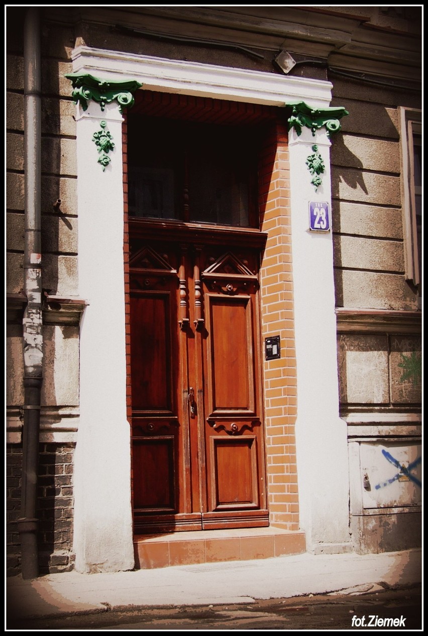 Brama z zielonymi ozdobami kolumn przy ulicy Długiej