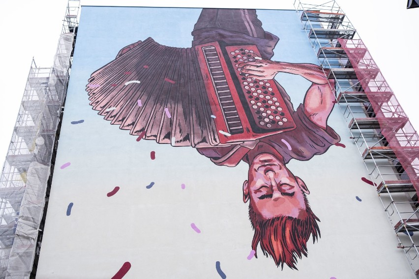Nowy mural w Warszawie. Uliczny grajek do góry nogami