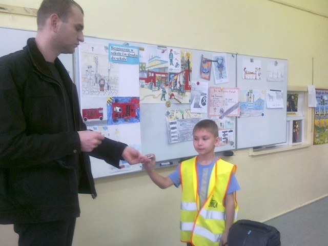 Naczelnik OSP Wojnowice, wręcza dzieciom odblaski, kt&oacute;re ratują życie. Fot. Justyna Bartkowiak