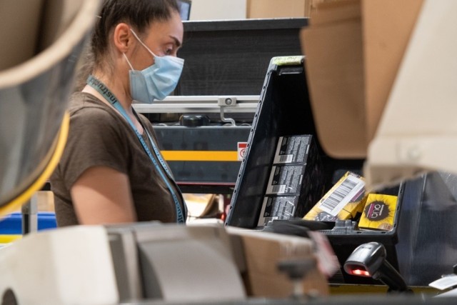 W kantynie sosnowieckiego Amazonu pracownicy mogą się poruszać tylko w ramach narysowanych na podłodze specjalnych "bezpiecznych" korytarzy, gdzie oznaczono nawet w którym miejscu powinni stać ludzie. Firma daje pracownikom maseczki.