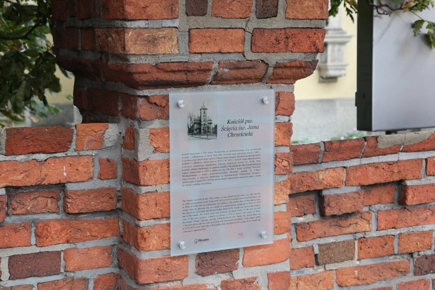 Na fasadach budynków zawisły historyczne tablice informacyjne