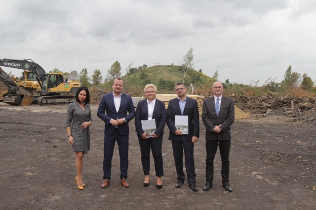 Plac budowy stadionu piłkarskiego na terenach niedaleko Górki Środulskiej, a na nim przedstawiciele inwestora i wykonawców