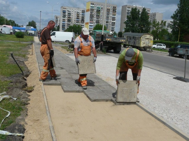 Pracownicy ZDiZM układają chodnik, który ze względu na zatoki parkingowe trzeba nieznacznie przesunąć.