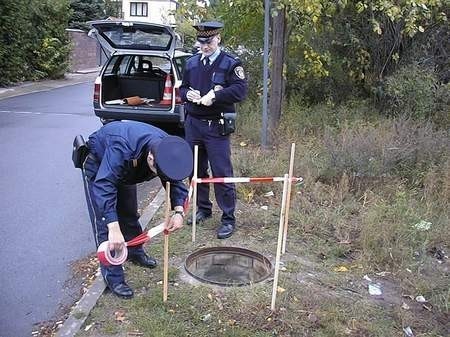 W taką okradzioną studzienkę, jaką zabezpieczają strażnicy, może łatwo wpaść i pokaleczyć się pieszy, czy rowerzysta. Fot. G. Okoński