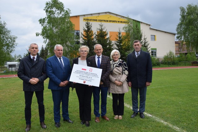 Poseł Gwiazdowski wraz z samorządowcami powiatu sejneńskiego na tle budowanego Powiatowego Centrum Sportu w Sejnach